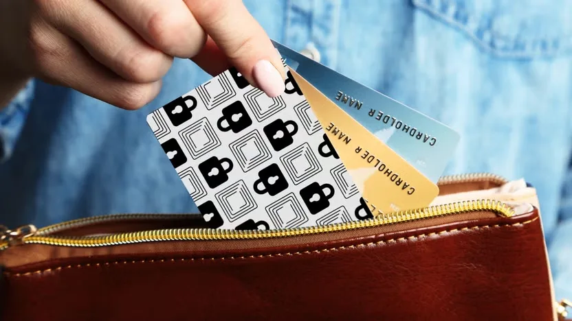 Carte Wallet Defender anti-RFID glissée dans un portefeuille en cuir à côté de cartes bancaires